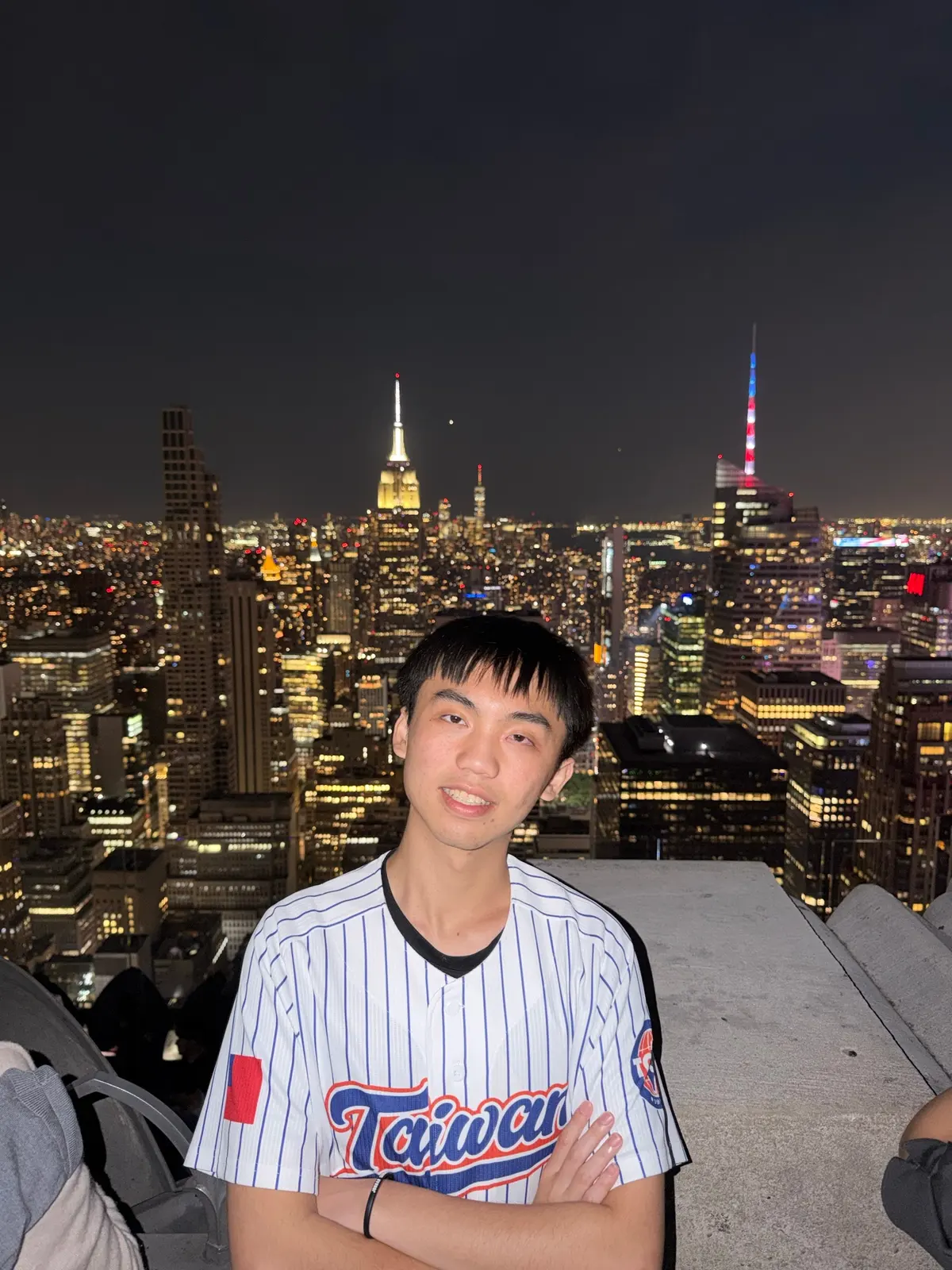 Alen Hsiao at night above Manhattan, the Empire State Building behind.